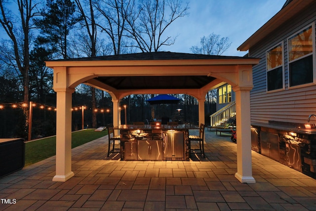 view of patio featuring a gazebo, exterior kitchen, outdoor dry bar, and outdoor dining space