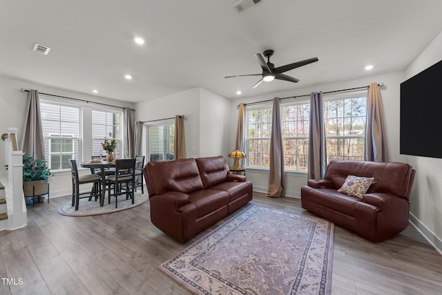 living room with light wood-type flooring, a healthy amount of sunlight, and visible vents