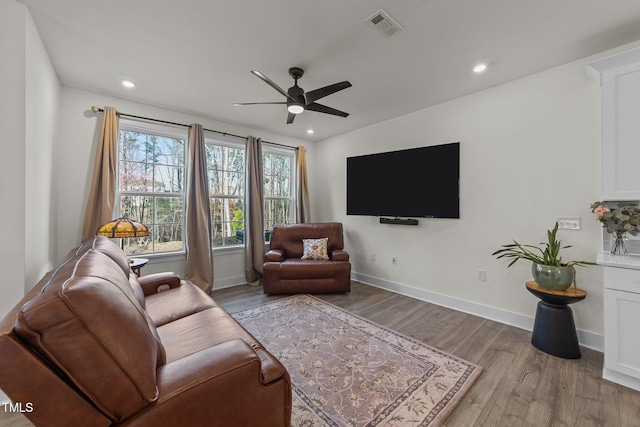 living room featuring recessed lighting, visible vents, light wood-style flooring, ceiling fan, and baseboards