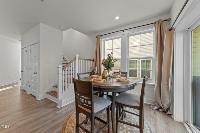 dining area featuring stairs, recessed lighting, light wood-type flooring, and baseboards