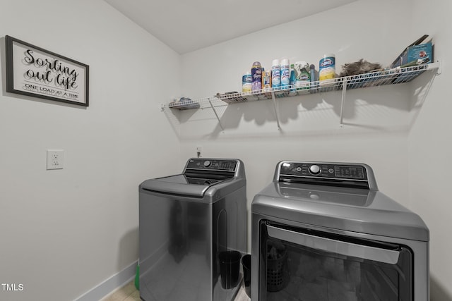 laundry area with laundry area, baseboards, separate washer and dryer, and tile patterned floors