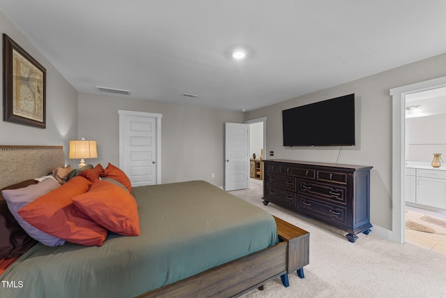 bedroom featuring visible vents, connected bathroom, light carpet, and baseboards