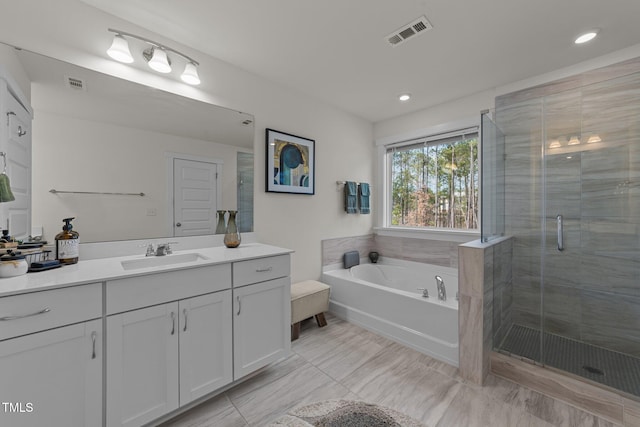 bathroom featuring a garden tub, a stall shower, vanity, and visible vents