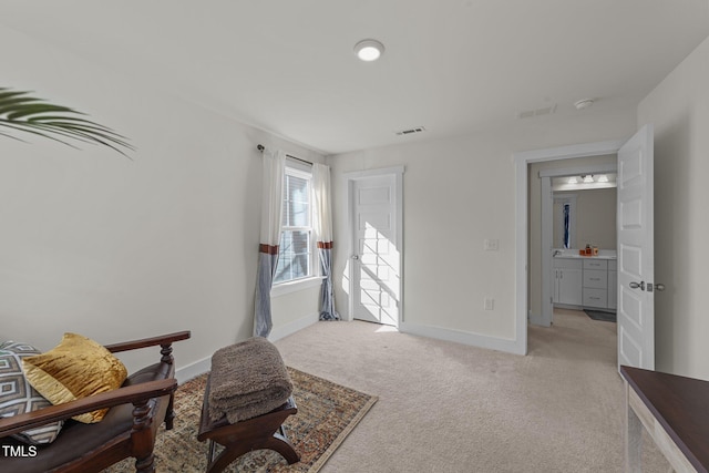 sitting room featuring light colored carpet, visible vents, and baseboards