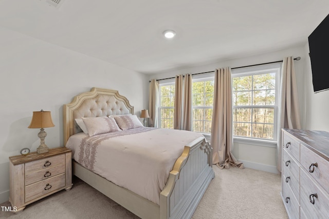 bedroom with light colored carpet and baseboards