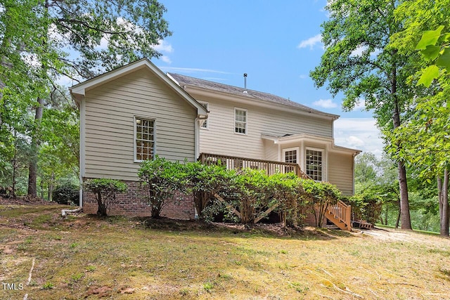 back of property featuring stairway, a deck, and a yard