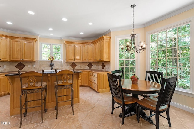 kitchen with a center island, crown molding, a notable chandelier, decorative backsplash, and a kitchen bar