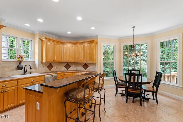 kitchen featuring tasteful backsplash, ornamental molding, a healthy amount of sunlight, a sink, and dishwasher