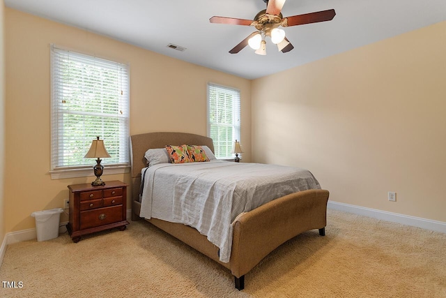 bedroom with light carpet, ceiling fan, and baseboards