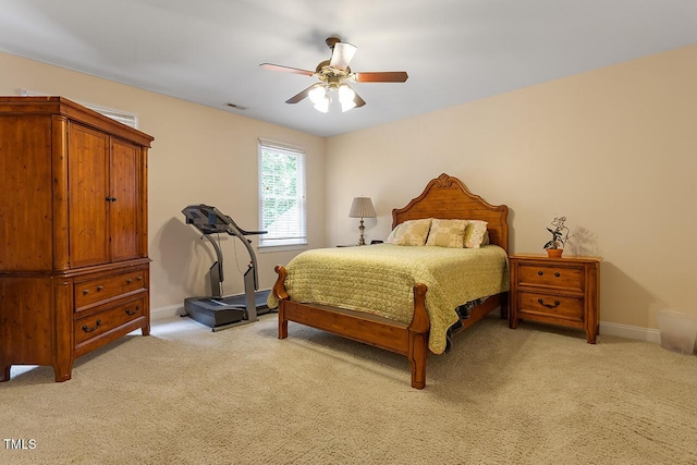 bedroom with light carpet, ceiling fan, visible vents, and baseboards