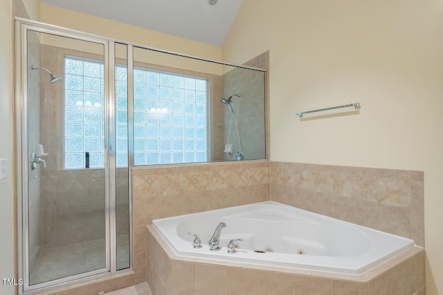 full bathroom with vaulted ceiling, a tub with jets, and a stall shower