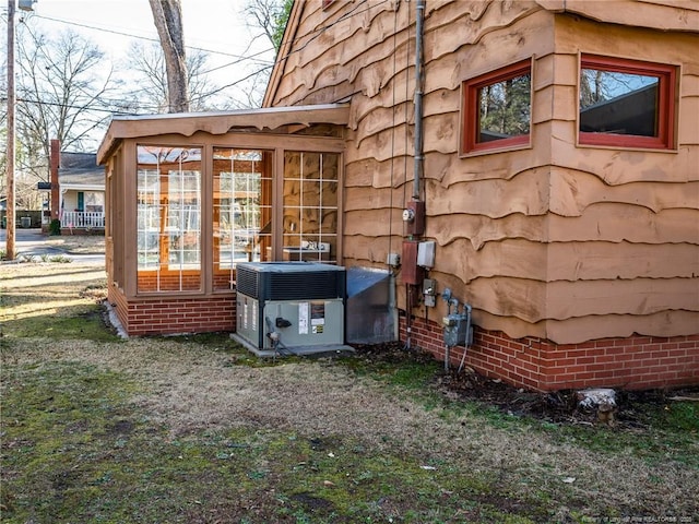 view of outbuilding featuring central AC unit and a sunroom