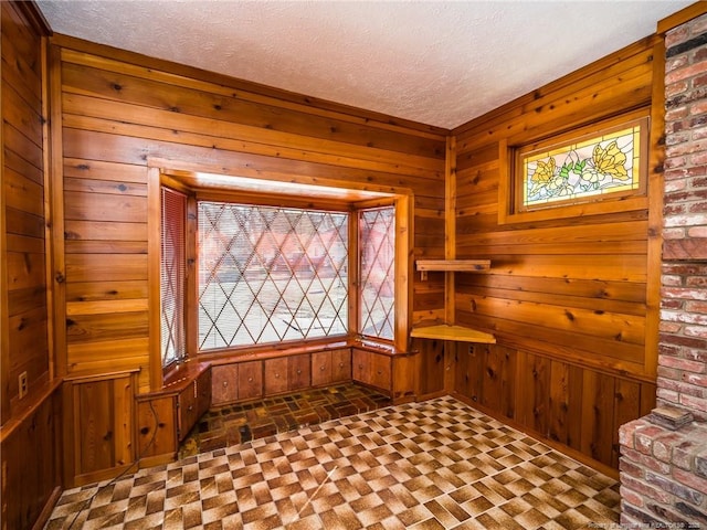 unfurnished room with wood walls and a textured ceiling