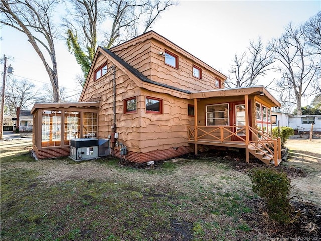 rear view of property featuring a sunroom