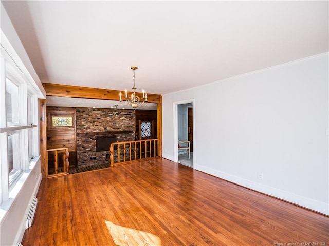 unfurnished living room featuring baseboards, wood finished floors, an inviting chandelier, baseboard heating, and beam ceiling