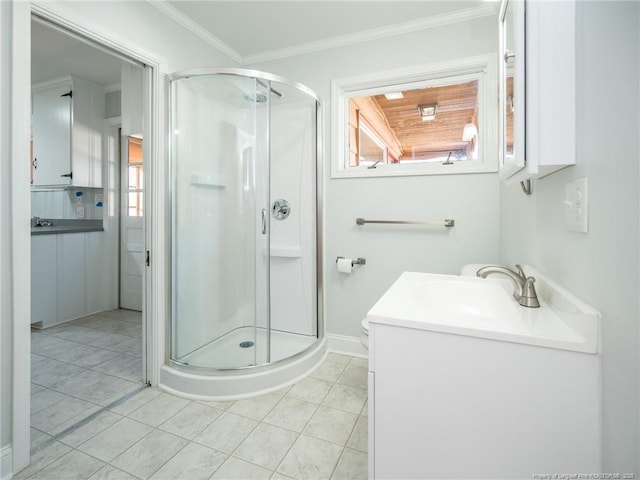 bathroom with baseboards, crown molding, a shower stall, and vanity