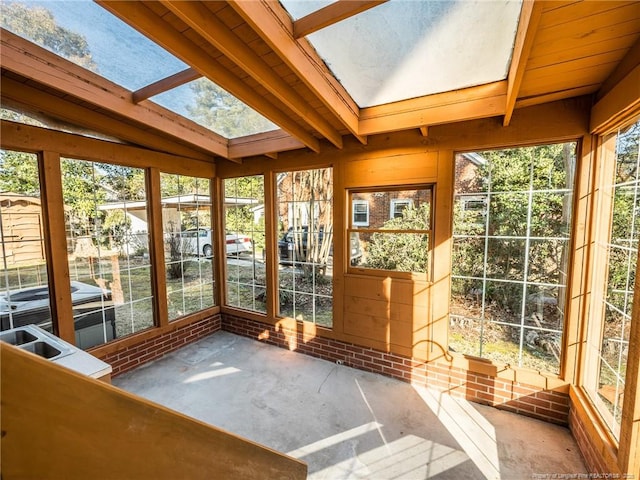 unfurnished sunroom with lofted ceiling with skylight