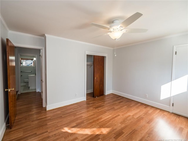 unfurnished bedroom with baseboards, crown molding, and light wood finished floors