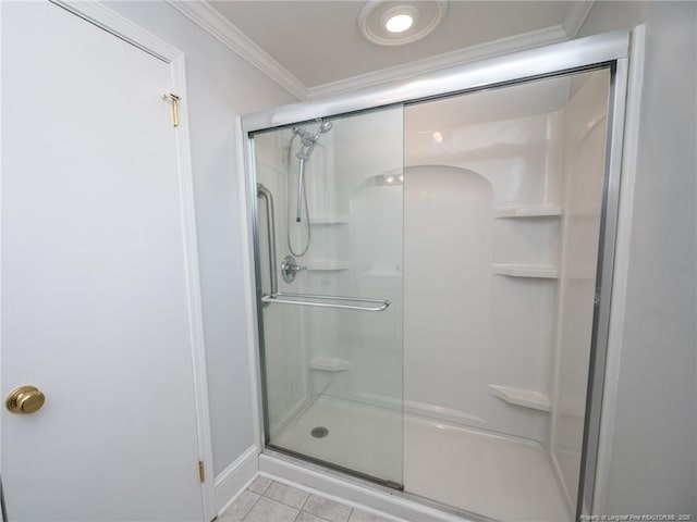 bathroom featuring a shower with shower door, crown molding, and tile patterned floors