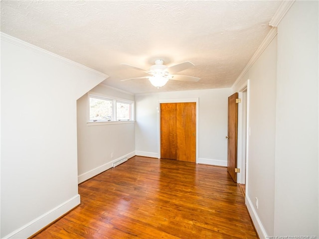 unfurnished bedroom with baseboards, crown molding, visible vents, and wood finished floors