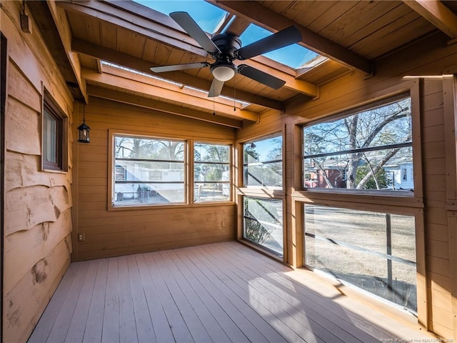 unfurnished sunroom with wood ceiling, a skylight, beam ceiling, and a ceiling fan