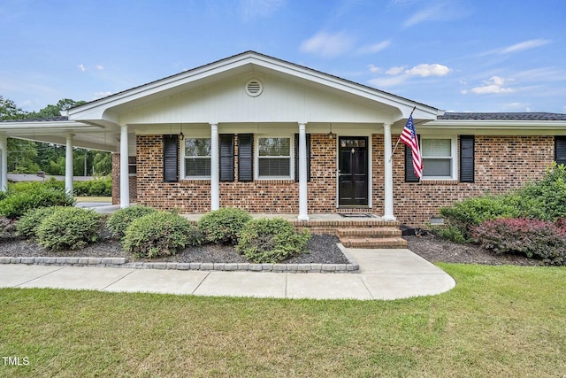 view of front of property featuring a porch, a front yard, and brick siding