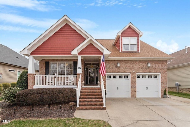 view of front of house with a shingled roof, covered porch, brick siding, and concrete driveway