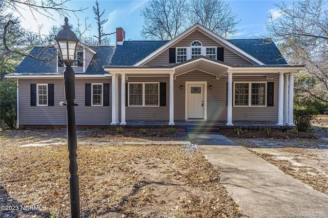 bungalow-style house with covered porch and a chimney