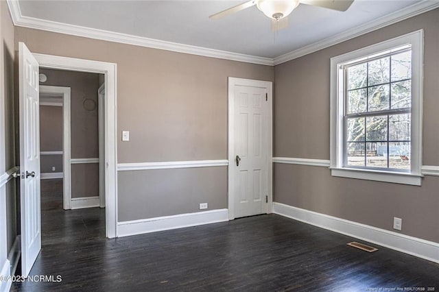 unfurnished room with ornamental molding, dark wood finished floors, and baseboards