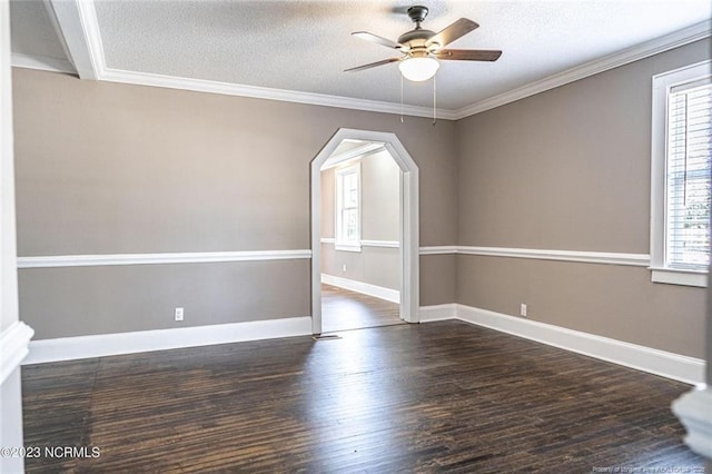 unfurnished room with ornamental molding, arched walkways, dark wood finished floors, and a textured ceiling