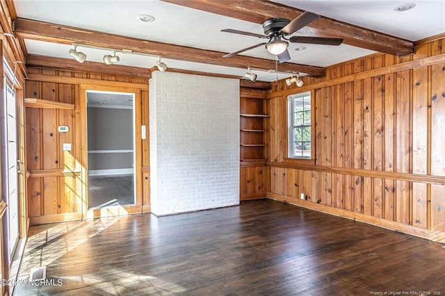 spare room with wooden walls, a ceiling fan, dark wood-type flooring, and beamed ceiling