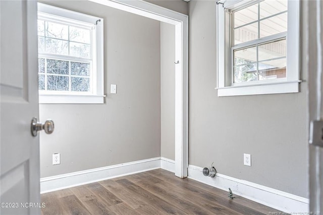 laundry area with laundry area, baseboards, and dark wood-style flooring