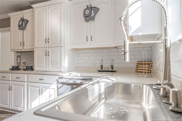 room details with white cabinets, light countertops, and decorative backsplash