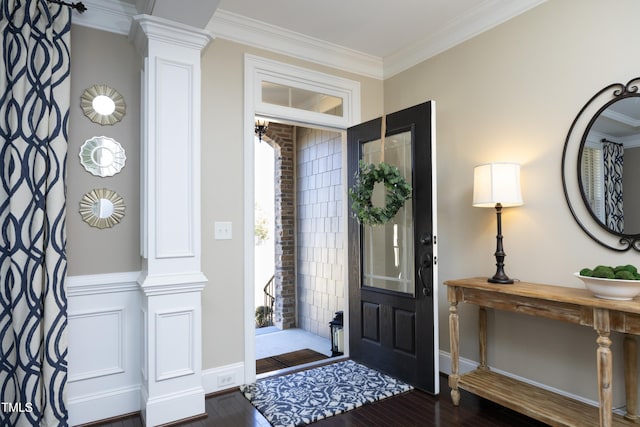 entryway with baseboards, ornamental molding, wood finished floors, and ornate columns