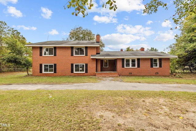 tri-level home with brick siding, a chimney, crawl space, fence, and a front yard