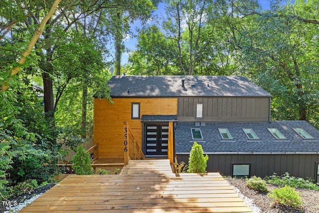 rear view of house with a shingled roof