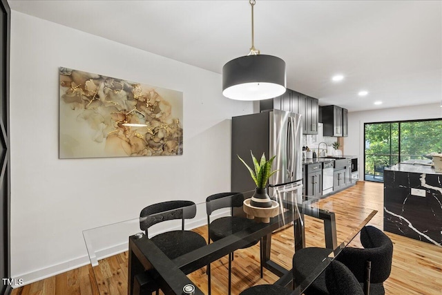 dining room with recessed lighting, light wood-type flooring, and baseboards