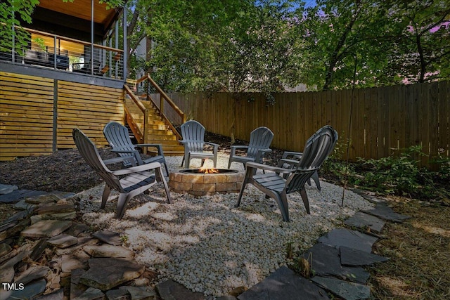 view of patio / terrace with stairway, fence, and a fire pit