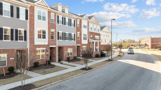 exterior space with sidewalks, street lighting, a residential view, and curbs