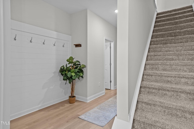 stairs with wood finished floors and baseboards