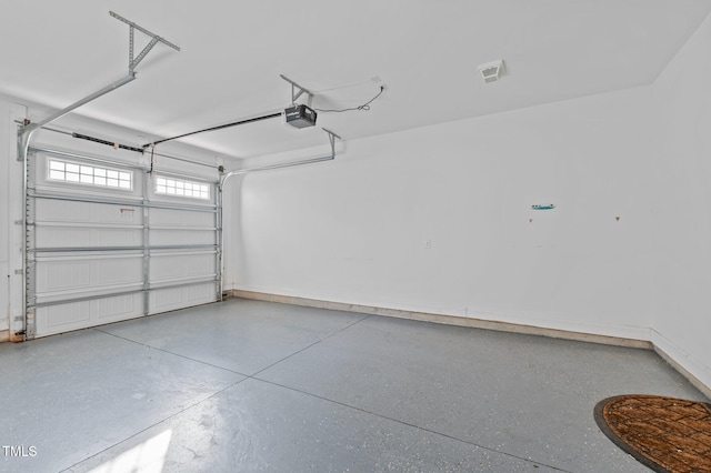 garage featuring a garage door opener and baseboards