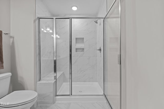 full bathroom featuring marble finish floor, a shower stall, and toilet