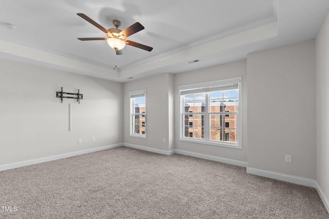 unfurnished room featuring a tray ceiling, visible vents, crown molding, and baseboards