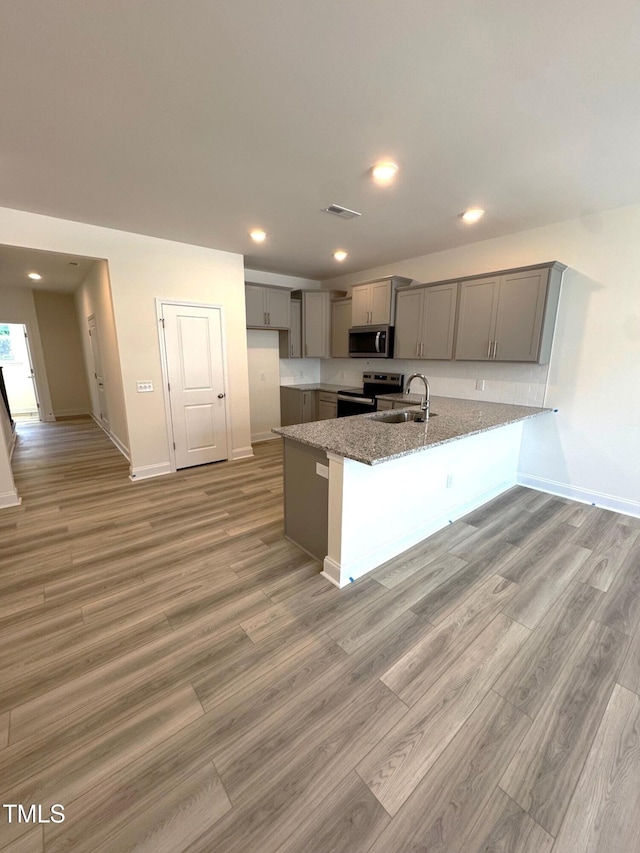 332 Church St Unit 45, Wendell, NC 27591 - kitchen featuring gray cabinetry, stainless steel appliances, a sink, a peninsula, and light wood-type flooring