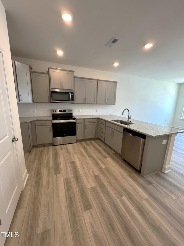 332 Church St Unit 45, Wendell, NC 27591 - kitchen featuring appliances with stainless steel finishes, gray cabinetry, a sink, a peninsula, and recessed lighting