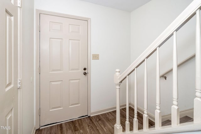 entryway featuring stairs, baseboards, and dark wood-type flooring