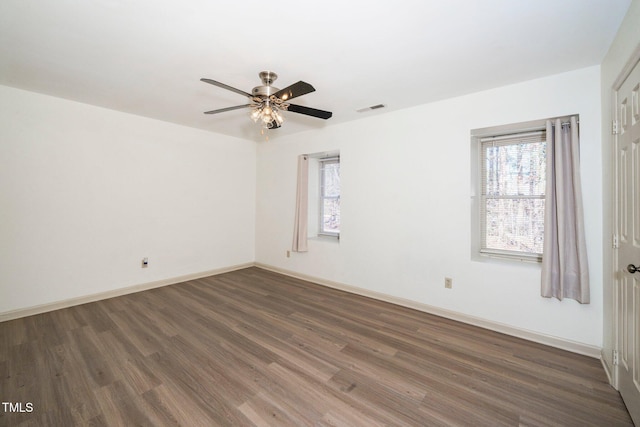 spare room with visible vents, baseboards, dark wood finished floors, and a ceiling fan