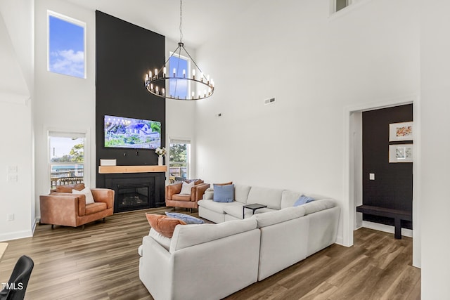 living room with a healthy amount of sunlight, visible vents, wood finished floors, and a glass covered fireplace