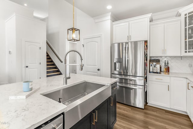 kitchen with stainless steel appliances, tasteful backsplash, glass insert cabinets, white cabinetry, and a sink