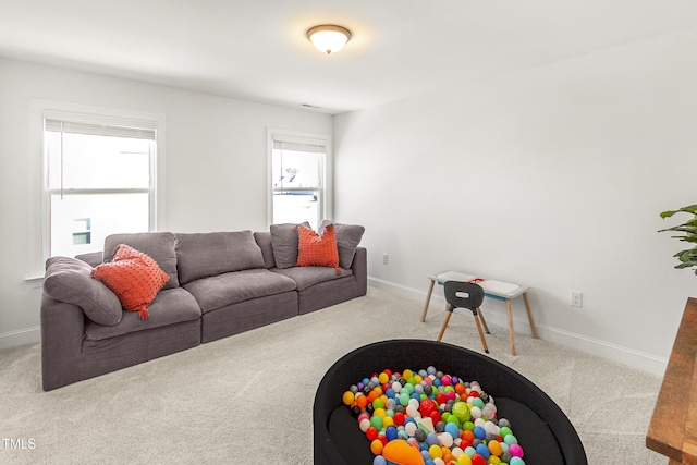 carpeted living room with a healthy amount of sunlight and baseboards